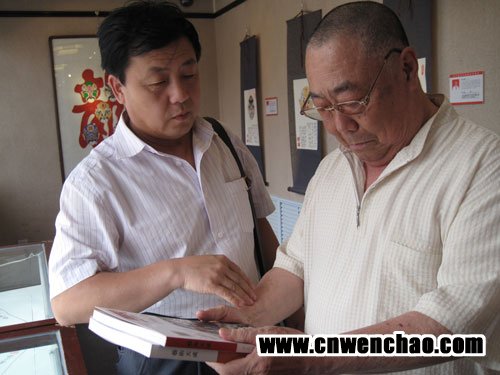 《艺术天成》杂志社总编杨文超左一与中国著名京剧大师袁少海共同欣赏《艺术天成》杂志