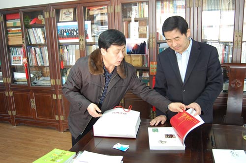 杨文超正在向罗杨介绍杂志