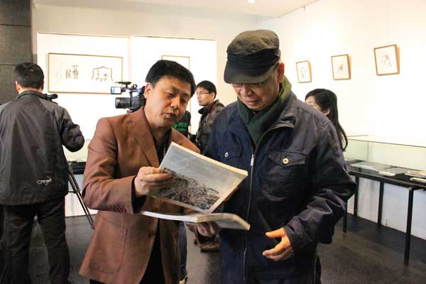 总编杨文超向著名画家、书法金石家张道兴介绍《艺术天成》杂志