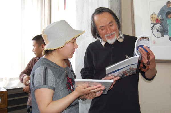 中国美术家协会会员邢少臣翻看《艺术天成》杂志
